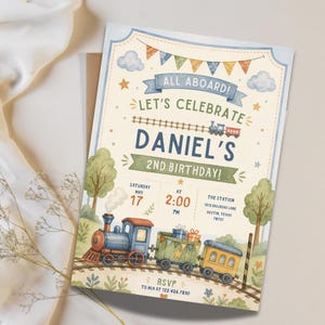 May include: A rectangular birthday invitation card featuring a watercolor train theme. The text reads: ALL ABOARD! LET'S CELEBRATE DANIEL'S 2ND BIRTHDAY! SATURDAY MAY 17 AT 2:00 PM THE STATION 1212 RAILROAD LANE AUSTIN, TEXAS 78701 RSVP TO MIA AT 122.456.7890.