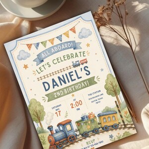 May include: A rectangular birthday invitation card featuring a watercolor train theme. The text reads ALL ABOARD! LET'S CELEBRATE DANIEL'S 2ND BIRTHDAY! with event details including the date, time, and location. The design includes a train, bunting, and trees.