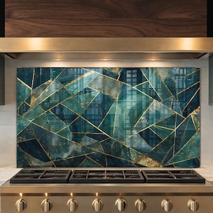 May include: A teal and gold geometric backsplash installed above a stainless steel gas range. The backsplash features a mosaic design with teal, blue, and gold tones. The kitchen has dark green cabinets and a light-colored countertop.