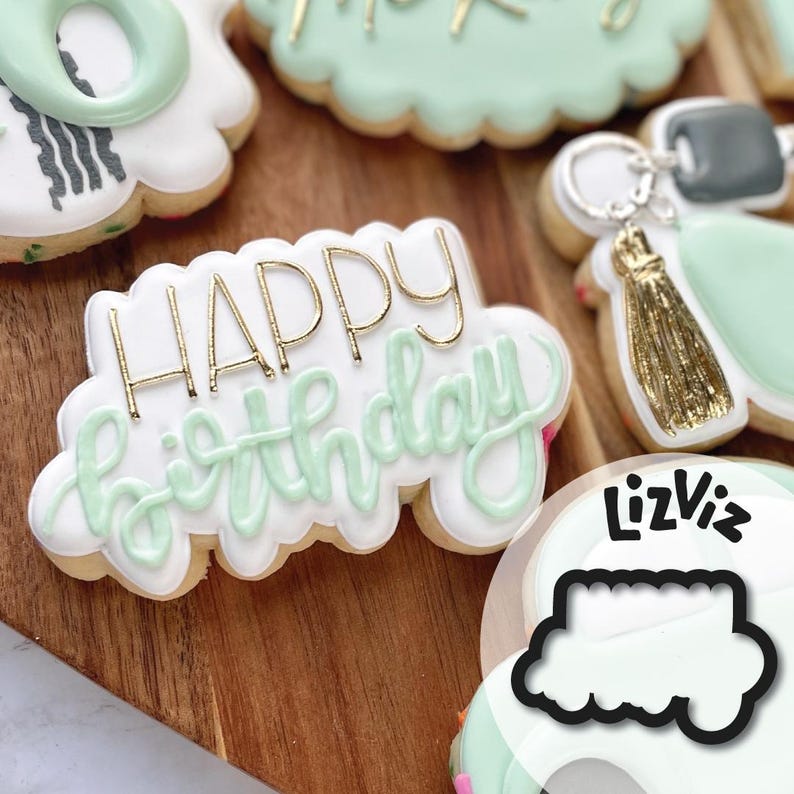 K&ouml;nnte beinhalten: Ein gr&uuml;ner und wei&szlig;er Keks mit goldener Aufschrift "Happy Birthday".