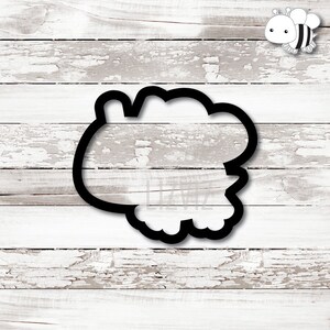 May include: Black cookie cutter shaped like a fluffy cloud with a rounded edge.