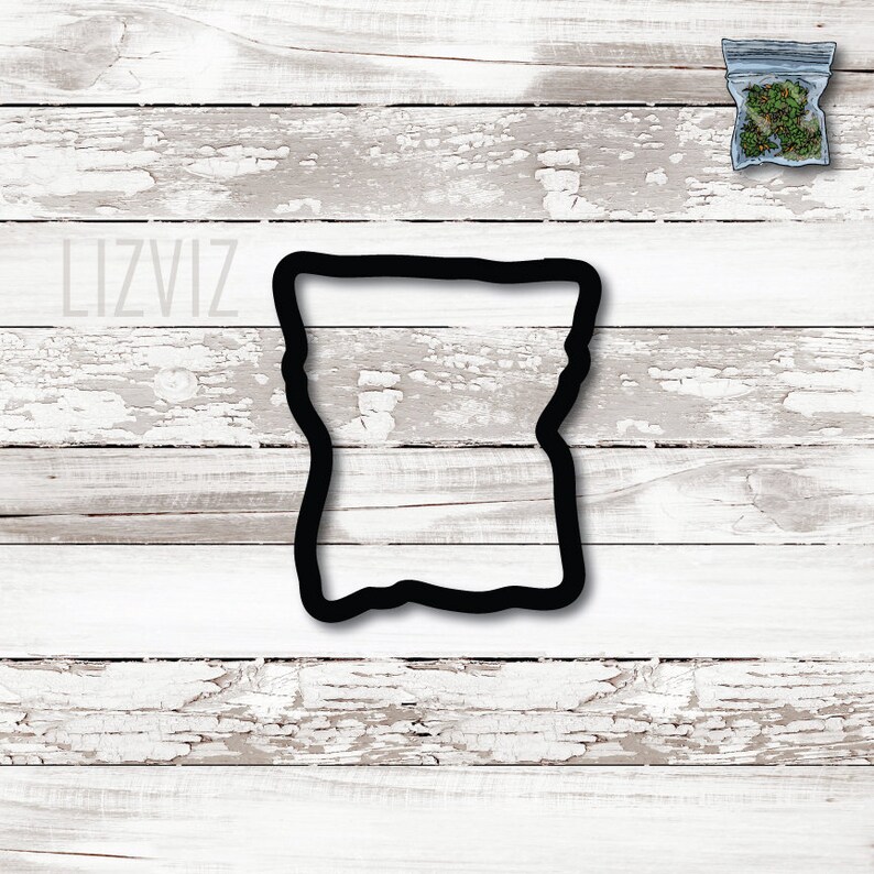 May include: Black cookie cutter shaped like a bag with a wavy top and bottom. The cookie cutter is on a white wood background.