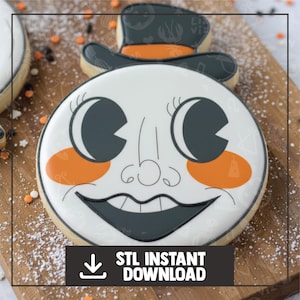 May include: A decorated sugar cookie with a smiling face design, featuring a white base, black eyes and mouth, and orange cheeks. The cookie is topped with a black hat with orange accents. The text "STL INSTANT DOWNLOAD" is displayed on a black banner.