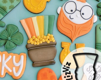 Könnte beinhalten: Ein Set aus neun dekorierten Zuckerkeksen mit verschiedenen Motiven zum Thema St. Patrick's Day, darunter ein Topf voller Gold, ein Regenbogen, ein Kobold, ein Hufeisen und Kleeblätter. Die Kekse sind mit grünem, orangefarbenem, gelbem und weißem Zuckerguss verziert.