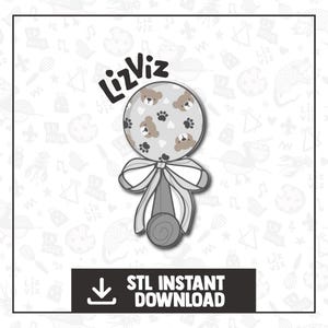 May include: A gray and white rattle with a brown bear print. The rattle has a bow and a handle. The text "LizViz" is written in black above the rattle.