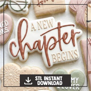 May include: A collection of decorated cookies with a white base and brown lettering. The central cookie reads "A New Chapter Begins". Other cookies include heart and cloud shapes. A black banner at the bottom reads "STL Instant Download".