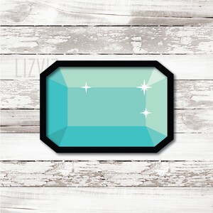 May include: A teal blue gemstone with a black border and three white stars. The gemstone is on a white wood background.