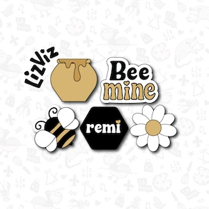 May include: Six bee-themed stickers with a honey pot, a bee, a daisy, a hexagon with the word "remi" and a heart, and a sticker that says "Bee mine" with a heart.