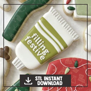 May include: A selection of decorated biscuits. The central biscuit is shaped like a tube of filling, with the words "filling festive" in white. Other biscuits include a green mitten, a red biscuit with green and white decorations, and a green biscuit with white icing.