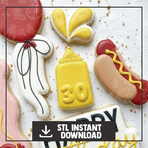 Puede incluir: Surtido de galletas de azúcar decoradas, que incluyen una botella de mostaza amarilla con el número 30, un perrito caliente con mostaza y un lazo blanco. La imagen también incluye el texto "STL INSTANT DOWNLOAD".