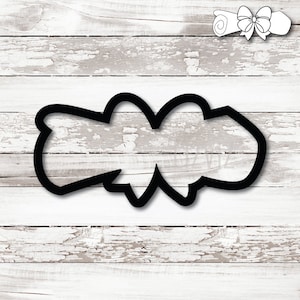 May include: Black cookie cutter in the shape of a scroll with a bow. The cutter is on a white, distressed wood background. A smaller scroll with a bow is in the upper right corner.