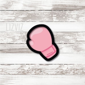 May include: Pink boxing glove cookie cutter with a black outline.