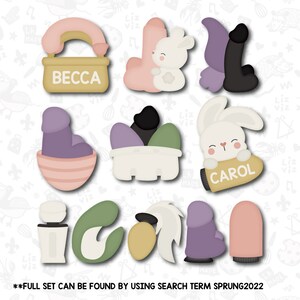 May include: A set of nine cookie cutters featuring various designs, including a bunny holding a carrot, a basket with eggs, a boot, and a bottle. The cutters are made of metal and have a gold finish. The text "BECCA" and "CAROL" are visible on two of the cutters.