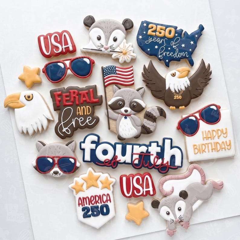 May include: A collection of decorated sugar cookies in various shapes and designs. The cookies include patriotic themes such as the USA, an American flag, an eagle, and the text "Fourth of July". Other cookies feature animals and sunglasses.