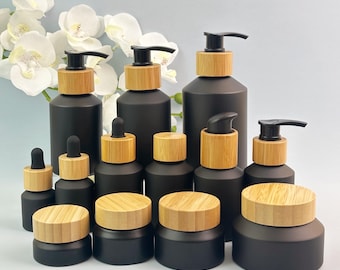 Frasco de vidro preto fosco para cuidados com a pele com tampa de bambu, frasco com bomba dosadora, frasco conta-gotas para sérum, pote para creme, óleo essencial e embalagem de produtos para o corpo.