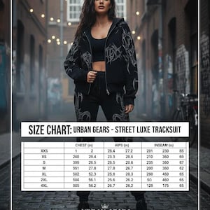 Op de afbeelding: Een vrouw poseert in een zwart trainingspak met een jas met rits en bijpassende broek. De outfit heeft een decoratief zilverkleurig ontwerp. Een maattabel voor het "Street Luxe Tracksuit" is inbegrepen, met afmetingen in inches voor borst, heupen en binnenbeenlengte.