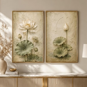 May include: Two rectangular wall art pieces in gold frames featuring textured, cream-colored backgrounds with raised, three-dimensional depictions of lotus flowers and large, round green lily pads in varying stages of bloom and growth.