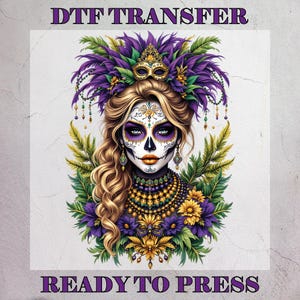 May include: DTF TRANSFER image featuring a detailed illustration of a woman with sugar skull makeup, adorned with a feathered headdress, mask, and ornate jewelry. The design incorporates purple, gold, and green colors, with the text "READY TO PRESS".