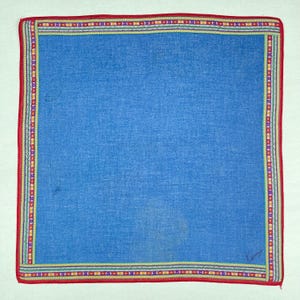 Peut inclure: Un mouchoir carré bleu avec une bordure rouge. La bordure présente un motif décoratif de rayures jaunes, vertes, violettes et rouges. Le mouchoir a un aspect texturé.