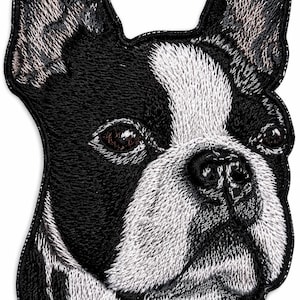 May include: An embroidered patch featuring the head of a Boston Terrier dog. The design displays the dog's characteristic black and white coat, upright ears, and dark eyes, rendered with detailed stitching against a solid black border outline.