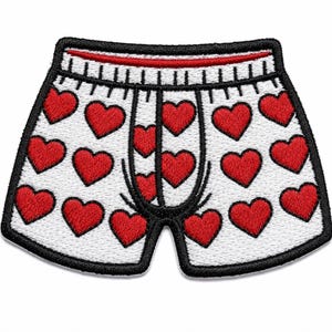 May include: An embroidered patch shaped like boxer briefs. The fabric is white with a repeating pattern of red hearts. The waistband is white with black vertical lines and a red top border. The entire patch is outlined in a thick black border.