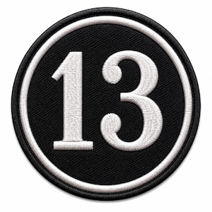 May include: A circular embroidered patch featuring a black background with a white border and the number 13 stitched in white in the center. The design uses a classic serif font for the digits, creating a high-contrast look suitable for fabric.