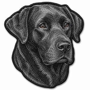 May include: An embroidered patch featuring a detailed portrait of a black Labrador Retriever dog. The design showcases intricate black and grey thread work to depict the fur texture, with two brown eyes and a black nose, finished with a black border.
