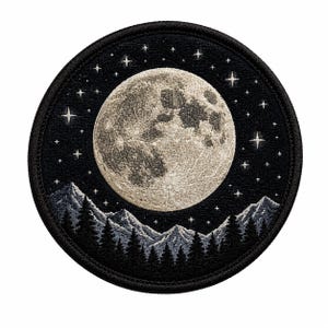 以下が含まれることがあります： 黒い夜空に浮かぶ大きなベージュの月と白い星々が刺繍された円形のワッペン。月の下には、濃い松林のシルエットと、その背後にギザギザとした明るいグレーの山々が描かれています。