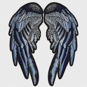 May include: A pair of embroidered patches shaped like wings, featuring detailed feather textures in shades of dark navy blue, light blue, and silver-grey. Each wing patch has a solid black stitched border outlining the entire wing shape.