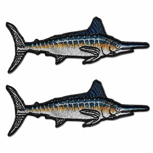 May include: Two identical embroidered patches shaped like marlin fish. Each patch features a dark blue dorsal fin, a long pointed bill, and a body with a gradient of deep blue, golden yellow, and white tones, all outlined with a black border.