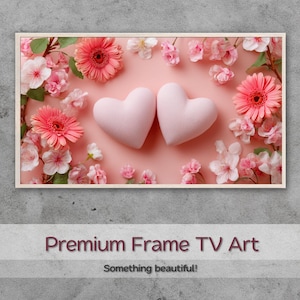 Könnte beinhalten: Ein gerahmtes Kunstwerk mit zwei hellrosa herzförmigen Objekten, umgeben von rosa Gerbera-Gänseblümchen und Kirschblüten auf rosa Hintergrund. Der Text "Premium Frame TV Art" und "Something beautiful!" steht unten.