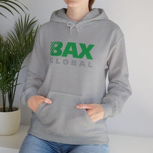 May include: A grey hooded sweatshirt with a front pocket and a drawstring hood. The sweatshirt has the green text "BAX" above the grey text "GLOBAL". The person is wearing blue jeans.