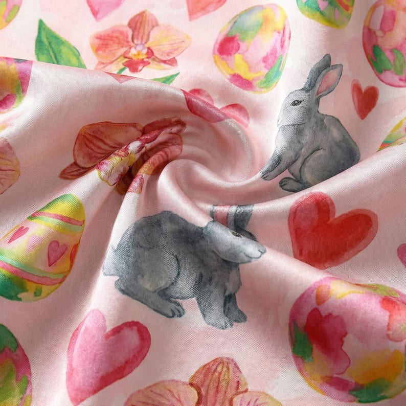 Puede incluir: Una tela rosa con un patr&oacute;n repetido de huevos de Pascua, conejos grises, corazones rosas y elementos florales. El dise&ntilde;o de acuarela presenta colores pastel y una textura suave y fluida, ideal para proyectos de primavera.