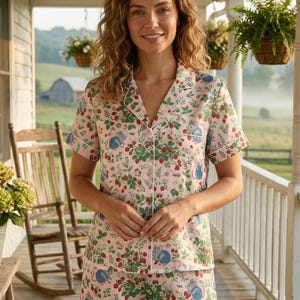 Puede incluir: Conjunto de pijama rosa con estampado de fresas y ratones. La camiseta de manga corta y los pantalones cortos tienen ribetes blancos. El estampado incluye fresas rojas, hojas verdes y ratones azules.