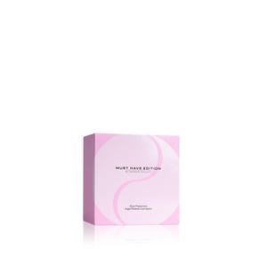 May include: A square, light pink product box featuring a white circular graphic design. The text on the front reads "MUST HAVE EDITION BY ESSENG BEAUTY" followed by "Eye Patches" and "Age Reset Complex" in a clean, dark sans-serif font.