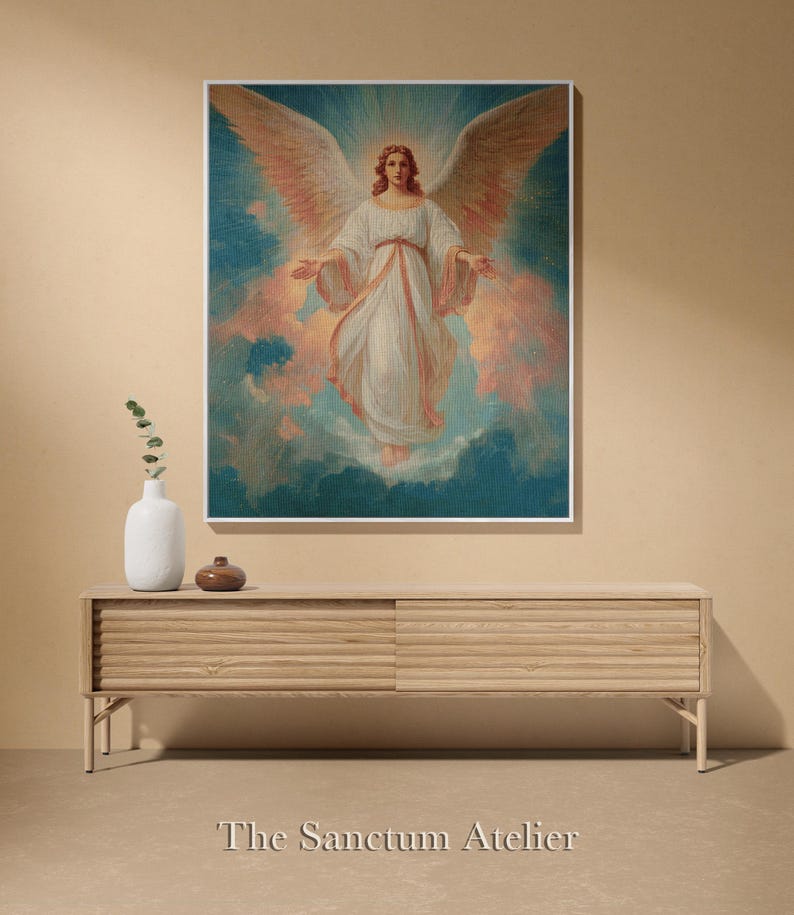 May include: A framed artwork featuring a celestial figure with large, outstretched wings. The figure is dressed in white robes, set against a backdrop of blue and peach hues. The artwork is displayed above a wooden console.