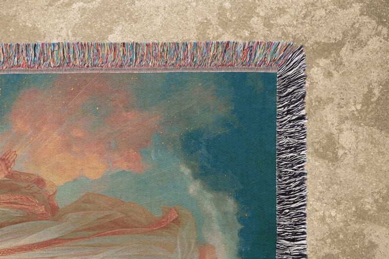 May include: A woven throw blanket featuring a detail of a classical painting with a teal background and peach-colored clouds. The blanket has a fringed edge with a mix of colors, including red, blue, and orange.