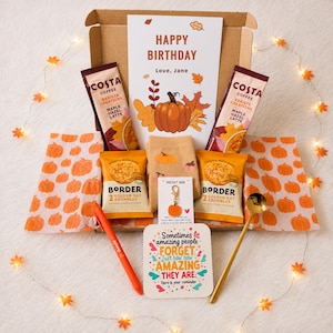 May include: A birthday gift box containing two Costa Coffee maple hazel latte sachets, two Border golden oat crumbles, a pair of tan socks, a pumpkin charm, an orange pen, a gold spoon, and cards with pumpkin and inspirational text designs.