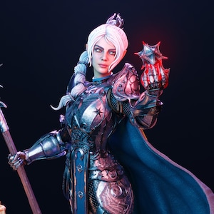 May include: A detailed figurine of a female warrior with white hair and silver armor. She holds a glowing red star-shaped object in her right hand. The figure is set against a dark background, with a blue cape and staff.
