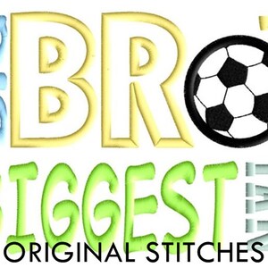 Puede incluir: Diseño bordado con las palabras "Big Bro's Biggest Fan" en verde, amarillo y azul. Se incluye un balón de fútbol blanco y negro en el diseño.