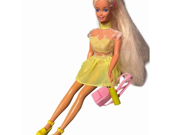 Muñeca Barbie rubia vintage de los 90 con ojos morados, atuendo neón y accesorios.