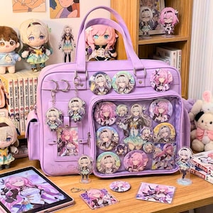 May include: A lilac satchel bag with character pins and keychains. The bag has a clear front pocket filled with character pins. Plush dolls and figurines are arranged around the bag, creating a themed display.