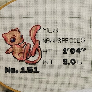 May include: Cross-stitch embroidery of a pink Mew Pokemon with the text "NEW SPECIES" and "No. 151". The text also includes the Pokemon's height as 1'04" and weight as 9.0 lb.