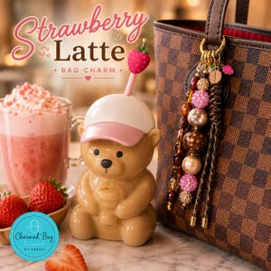 May include: A bag charm featuring a brown bear figure wearing a pink and white cap with a strawberry topper, attached to a brown checkered handbag. The charm includes a strand of multi-colored beads and a small coffee bean pendant.
