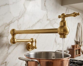 May include: A wall-mounted brass pot filler tap with a double-jointed swing arm and a lever handle, dispensing a steady stream of water into a large copper pot. The tap features a metallic gold finish and a classic, articulated design.