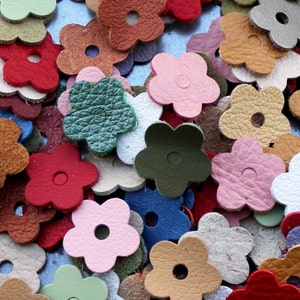 May include: Assortment of colorful leather flower shapes with a hole in the center. The flowers are in various shades of red, pink, green, blue, brown, and white.