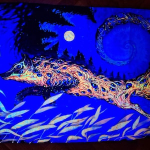 Op de afbeelding: Een levendig schilderij van een wolf met een lange, spiraalvormige staart, tegen een diepblauwe nachthemel. Het lichaam van de wolf is versierd met ingewikkelde patronen van oranje, geel en blauw. Een volle maan en silhouetbomen maken de mystieke scène compleet.