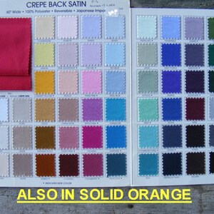 May include: A color chart for crepe back satin fabric. The chart shows a variety of colors, including red, yellow, pink, blue, green, and brown. The chart also includes the text "CREPE BACK SATIN" and "ALSO IN SOLID ORANGE".
