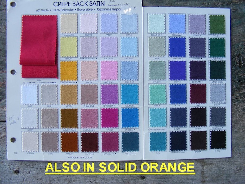 May include: A color chart for crepe back satin fabric. The chart shows a variety of colors, including red, yellow, pink, blue, green, and brown. The chart also includes the text "CREPE BACK SATIN" and "ALSO IN SOLID ORANGE".