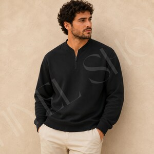 Peut inclure: Un sweat-shirt noir à manches longues doté d'un col zippé quart de tour avec une tirette noire assortie. Le vêtement présente un col, des poignets et un ourlet côtelés, offrant une coupe structurée. Le tissu semble être en coton opaque.